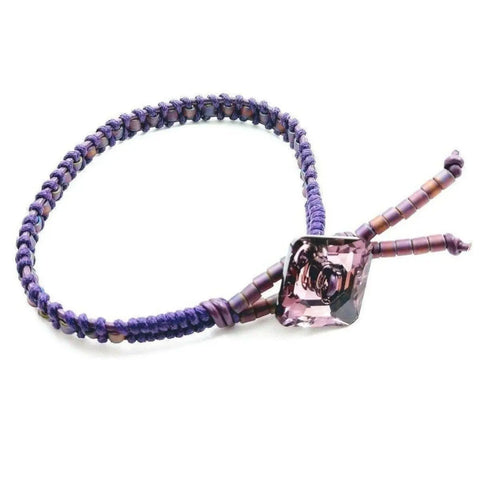 The Amethyst Braided Leather Swarovski Crystal Square Button Bracelet by Alexa Martha Designs features a purple braided leather band, a square Swarovski crystal centerpiece, and is an elegant piece of handmade Montana jewelry.