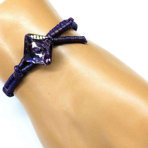 The Amethyst Braided Leather Swarovski Crystal Square Button Bracelet by Alexa Martha Designs is shown on a mannequin wrist against a white background, highlighting the elegance of this handmade Montana jewelry piece.