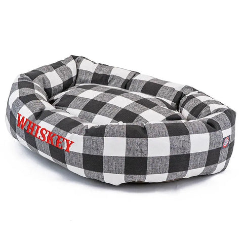 The Majestic Pet Anderson Check Bagel Bed features black and white buffalo plaid, raised edges, a soft cushioned interior, machine washable fabric, and can be personalized with WHISKEY embroidered in red on the side.