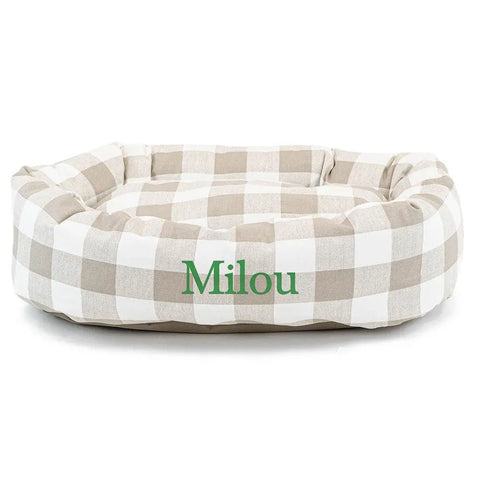 The Majestic Pet Anderson Check Bagel Bed - Personalized features a beige and white checkered design with Milou in green, raised sides, plush cushioned interior, and spine support for stylish comfort.