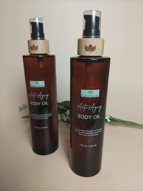 Two brown bottles of Forev'Herbs Anti-Aging Body Oil with black pumps and wooden accents sit on a beige surface, a white flower in the background. Labels emphasize rejuvenating oils for youthful, revitalized skin.