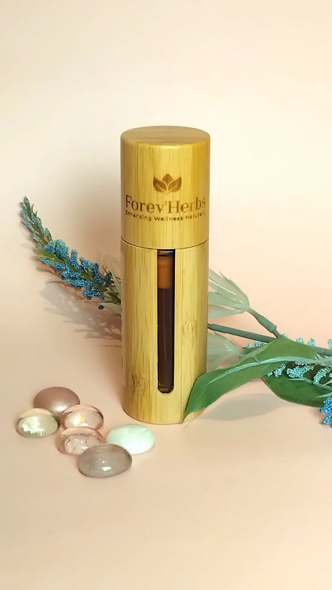 A cylindrical Forev'Herbs bamboo bottle stands upright by smooth stones, a green ribbon, and foliage, ideal for highlighting the Anti-Aging Facial Serum or a natural retinol alternative on a pale background.