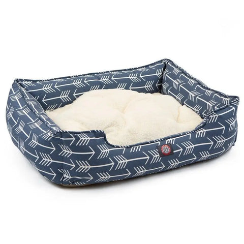 The Majestic Pet Arrow Contemporary Lounge Bed features a rectangular design with raised sides, a low front opening, soft cream cushion, blue outer fabric with white arrows, and is fully machine washable.