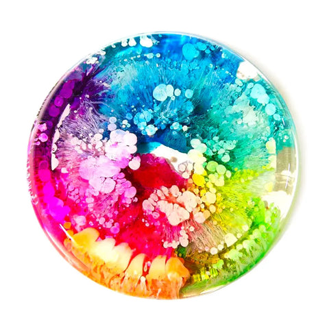 A round petri dish showcases vibrant colors and abstract swirls with bubbles, resembling a chemical reaction or resin art created using ArtResin Alcohol Ink by ArtResin on a white background.