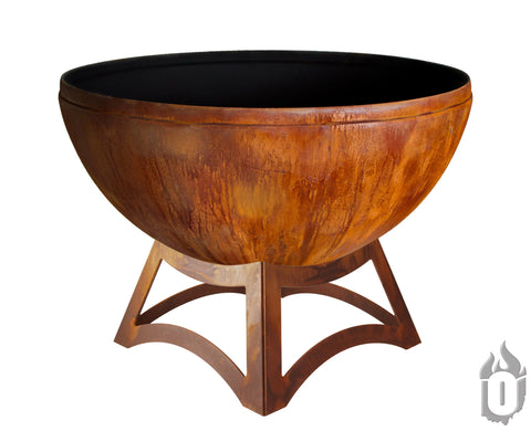 The Ohio Flame Fire Chalice Fire Bowl With Hollow Base, made in the USA, features a large round rust-colored steel bowl on a sturdy geometric metal stand with an industrial look, shown against a white background.