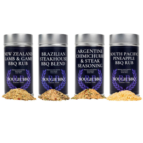 The Gustus Vitae Global Gourmet BBQ Collection - 4 Pack features four spice tins—New Zealand Lamb & Game BBQ Rub, Brazilian Steakhouse, Argentine Chimichurri & Steak Seasoning, and South Pacific Pineapple BBQ Rub—with gourmet spice piles in front.