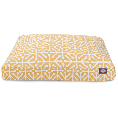 The Majestic Pet Aruba Rectangle Dog Bed features a yellow background with a white geometric branch pattern, premium polyester fiber fill, and a small black logo tag on the front corner.