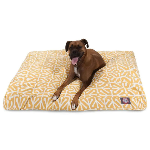A brown dog with a white chest lies on the Majestic Pet Aruba Rectangle Dog Bed, featuring a white bone pattern, premium polyester fiber fill, and a machine washable cover for easy care.