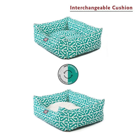 The Majestic Pet Aruba Contemporary Lounge Bed in turquoise features a white abstract pattern and an interchangeable cushion. One image shows the bed with a matching cushion, another with a plain white one. Text: Interchangeable Cushion.