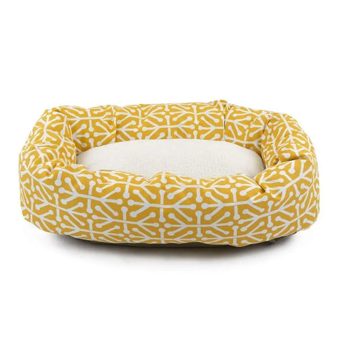 The Majestic Pet Aruba Sherpa Bagel Dog Bed is a yellow, water-resistant bed with raised sides, a white geometric pattern, and a soft plush white cushion for easy cleaning and comfort.