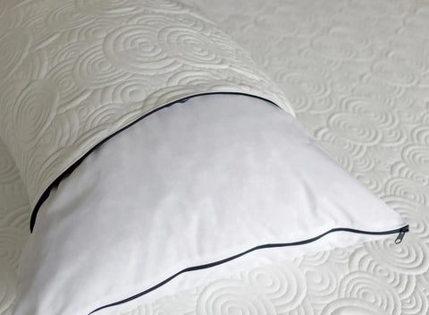 The Aslan Adjustable Pillow by Aslan Mattress, in white with a black zipper, rests on a matching mattress. Both feature textured fabric with circular swirl patterns, and the pillows open zipper partially reveals its memory foam interior.