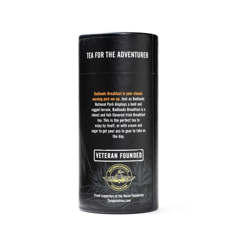 A cylindrical black canister from Sasquatch Tea Co labeled “Tea for the Adventurer.” It features Badlands Breakfast (Irish Breakfast Tea), a robust, veteran-founded blend, and includes a Green Beret Foundation badge.