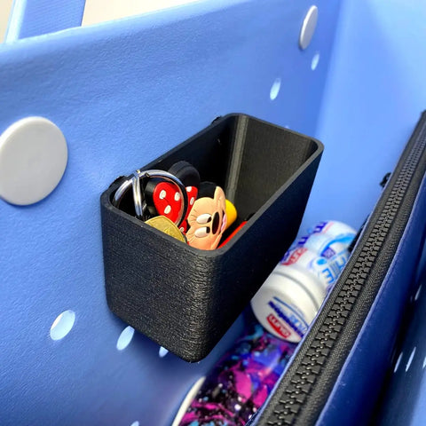 The Chatelet Manufacturing BOGLETS Organizer Charm Accessory, compatible with Bogg Bags, attaches to your tote to keep keys and small items handy. A nearby zippered pouch stores toothpaste and other essentials for a neat, organized setup.