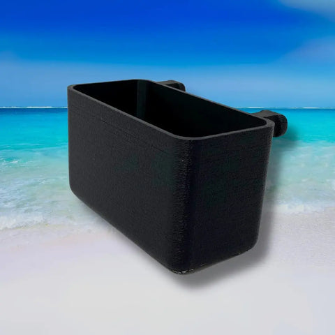 The BOGLETS Organizer Charm Accessory by Chatelet Manufacturing, compatible with Bogg Bags, rests on a sandy beach with turquoise ocean and a blue sky in the background, perfect for keeping keys or personal items handy with your tote.