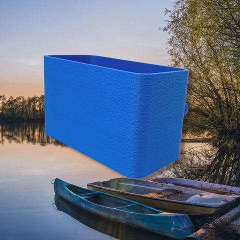 A BOGLETS Organizer Charm Accessory by Chatelet Manufacturing, compatible with Bogg Bags, is digitally shown atop a tranquil lakeside sunset scene with two boats and tree-lined shores, emphasizing its use for keeping keys or personal items handy.