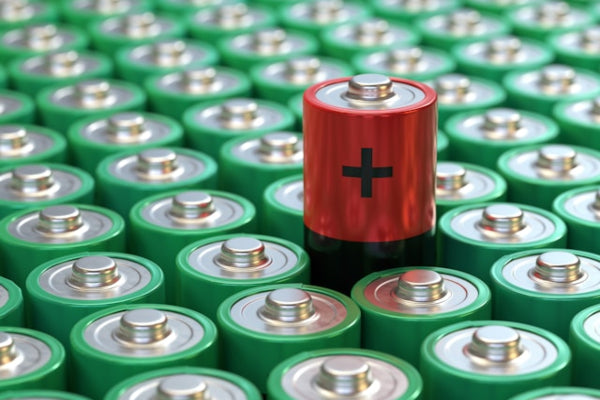 Red battery with a black cross on a background of green batteries