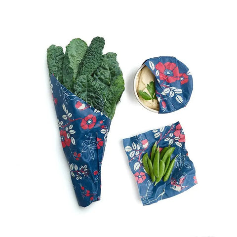 Keep food fresh with the Bees Wrap Assorted 3 Pack—plastic-free, reusable beeswax wraps featuring a blue floral pattern, perfect for leafy greens, snap peas, and crackers.