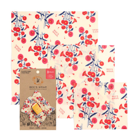 The Bee’s Wrap Assorted 3 Pack offers reusable food wraps in a red floral and berry design, displayed beside brown packaging—a plastic-free way to keep food fresh.