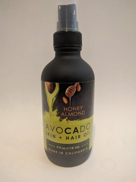 Bella Vado Avocado Oil Skin & Hair Oil (4oz), made in California, comes in a black spray bottle with honey almond scent—ideal as an avocado oil hair treatment or nourishing skin moisturizer.
