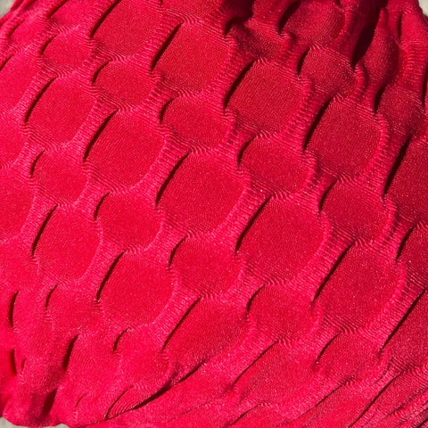 Close-up of the Scarves - Chemo Beanies® - Kendall by Chemo Beanies®, showing its bright red, honeycomb-textured fabric. The stylish slip-on design offers comfort and an intricate look, making it ideal cancer headwear.