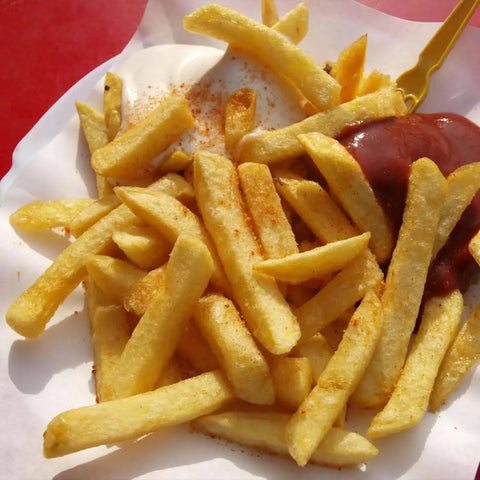 Golden French fries served on a white tray, topped with Gustus Vitae Better Than Butter Seasoning from the 2 Pack Set, with mayonnaise and ketchup on the side.