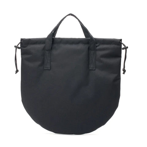 The MIS UK Helmet Bag - Black is a rounded tote made from water-resistant material, with short handles, adjustable side drawstrings, and multiple pockets, shown against a white background.