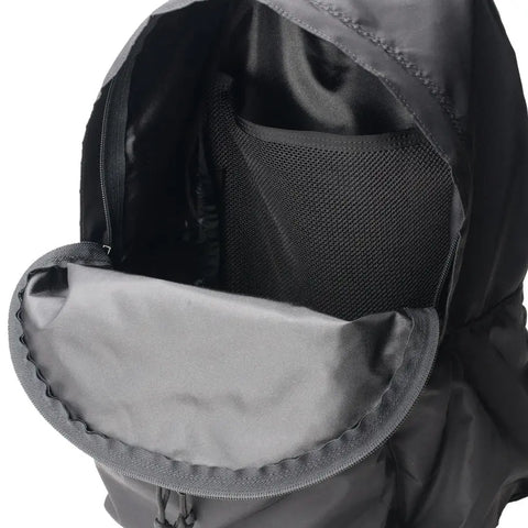 Close-up of the MIS Daypack - Black, featuring an open main compartment with a mesh pocket and smooth lining. The top flap is open, showing its spacious interior that fits a 13” laptop.