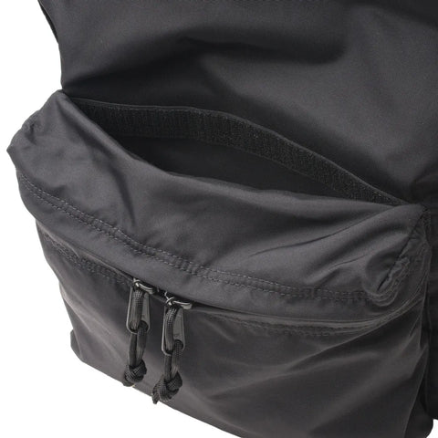 A close-up of the MIS Daypack - Black, showing its unzipped front pocket with dual zippers and a Velcro-secured inner compartment; water-resistant and fits a 13” laptop.