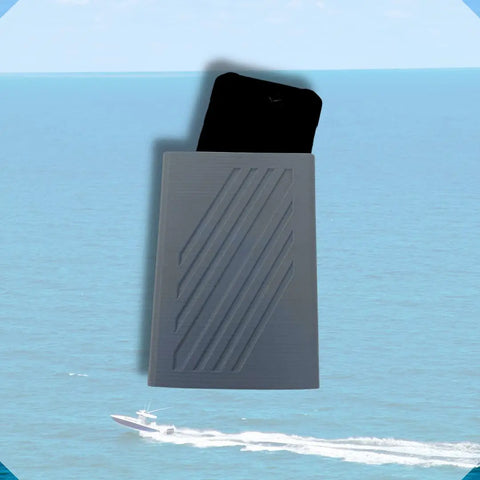 A black smartphone slides into the gray, weatherproof Chatelet Manufacturing Boat Phone Holder, featuring diagonal lines, set against an ocean scene with a white speedboat in the background.