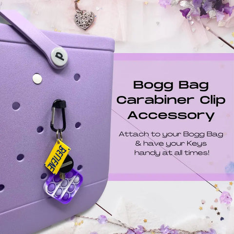 The BOGLETS by Chatelet Manufacturing is a purple carabiner keys holder charm for your Bogg Bag, letting you secure and organize keys or valuables. It even holds a pop-it toy, while the floral background adds cheer. Keep essentials handy with this cute accessory!.