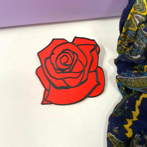 The BOGLETS Flower Charm Accessory by Chatelet Manufacturing features a bold, flat red rose with black outlines on white, plus blue, yellow, and purple accents—a cute way to customize your Bogg Bag.