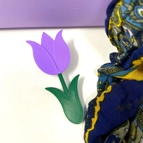 The BOGLETS Flower Charm Accessory by Chatelet Manufacturing features a purple 3D-printed tulip with a green stem, perfect for customizing your Bogg Bag as a cute and unique decorative accessory.