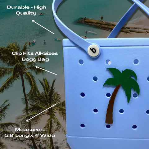 A light blue Chatelet Manufacturing Bogg Bag features a BOGLETS BEACH Charm and is shown at the beach. Arrows highlight its durability, universal clip fit, and 5.8 x 4 size. Personalize your bag with these decorative charms!.