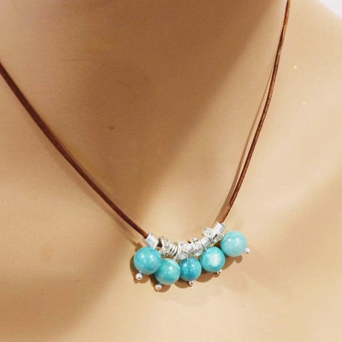 The Alexa Martha Designs Silver Green Blue Shell Bead Charm Leather Necklace is shown on a mannequin’s neck.