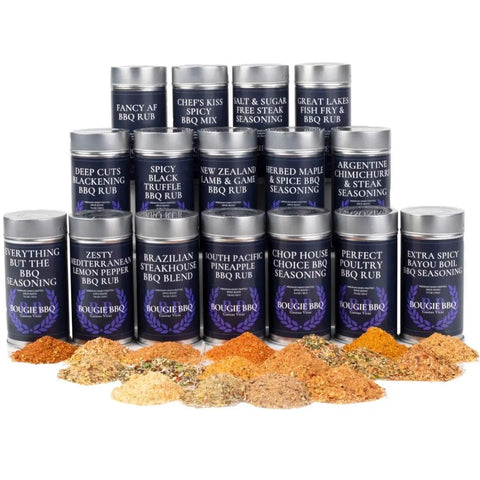 Sixteen tins from the Gustus Vitae Complete Bougie BBQ Collection - Sweet 16 are neatly arranged in rows, with vibrant piles of seasoning blends in front. Each tin features a dark blue label with its unique blend’s name.