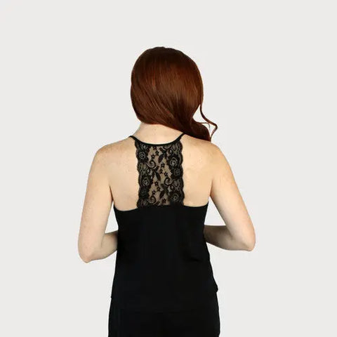A woman with long red hair is seen from the back, wearing the Goodnighties Lace Back Halter Top, featuring intricate lace detail. The plain light gray background highlights this stylish American-made sleepwear piece.
