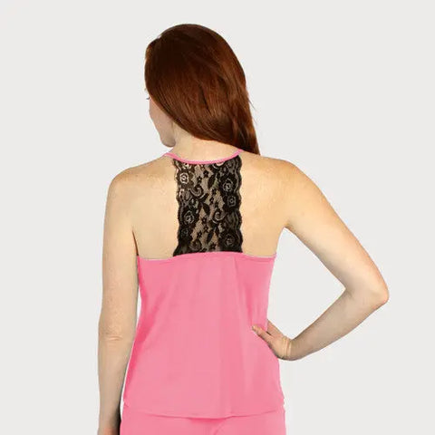 A woman with long red hair faces away, modeling the Goodnighties Lace Back Halter Top in pink with a decorative black lace panel. Her right hand rests on her hip against a plain light background.