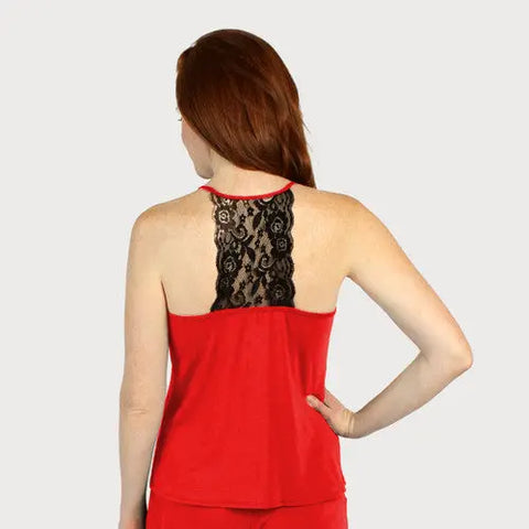 A woman with long red hair is shown from the back, wearing a Goodnighties Lace Back Halter Top featuring a black lace panel down the center. Her right hand is on her hip against a plain light gray background.