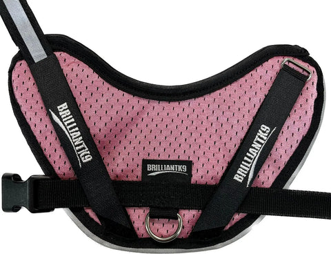 A BrilliantK9 Ergonomic Little Dog Harness 10lbs & Under - Summer Mesh in pink and black, featuring black straps, soft dual-layer jersey mesh, a metal ring, and plastic buckle, is displayed on a white background.