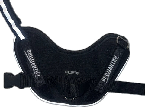 The BrilliantK9 Ergonomic Little Dog Harness for dogs 10lbs & under features summer mesh, dual layers of soft black jersey, white reflective stripes, “BRILLIANTK9” on adjustable straps, and a secure plastic buckle.