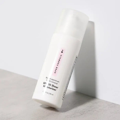 A white bottle of Open Formula SPF 30 Sheer Moisturizer with a pump dispenser lies on its side, casting a shadow—delivering blue-violet light protection to help prevent premature aging.