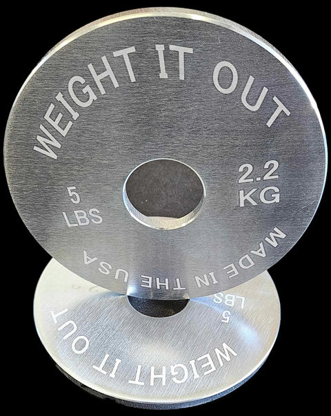 Two upright Solid Steel Calibrated Weight Plate Sets by Weight It Out are shown in silver, each engraved with Weight It Out, 5 LBS, 2.2 KG, and Made in the USA. Their reflection appears on the surface below.