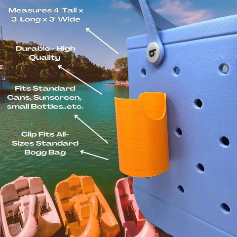 A blue tote features the FRESHe BAGLETS Can Drink & Water Bottle Holder by Chatelet Manufacturing, shown lakeside by paddle boats. This USA-made accessory is durable, fits Rubber Tote Bags, and is compatible with all Bogg bag sizes.
