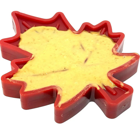 The SodaPup Canadian Maple Leaf EChew Durable Nylon Dog Chew Toy, shaped like a red maple leaf and veterinarian approved, is shown with yellow batter inside on a white background.
