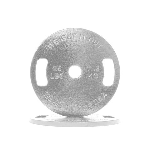 A silver 25 lb Cast Iron Machined Weight Plate Pair by Weight It Out stands upright, featuring dual grip handles, 25 LBS/11.3 KG and MADE IN THE USA inscriptions, and is made for Olympic bars. One plate lies flat beneath it.