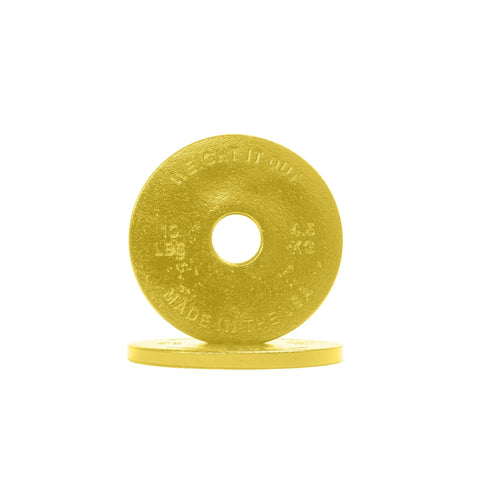 A yellow Weight It Out Cast Iron Machined Weight Plate stands upright before another plate, both embossed with kilogram and pound values for Olympic bars.
