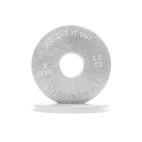 A silver Cast Iron Machined Weight Plate Pair from Weight It Out, marked 5 LBS, 2.3 KG, and MADE IN THE USA, stands upright on another plate, highlighting precision craftsmanship against a white background.