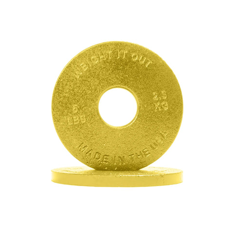 A gold Cast Iron Machined Weight Plate Pair from Weight It Out, stamped 5 LBS, 2.3 KG, and MADE IN THE USA, stands upright on another plate—perfect for Olympic bar training with minimal weight variance.