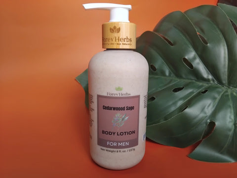 A bottle of Forev'Herbs Cedarwood Sage Lotion with a pump sits by a green leaf on an orange background, showcasing this natural men's moisturizer ideal for daily use.