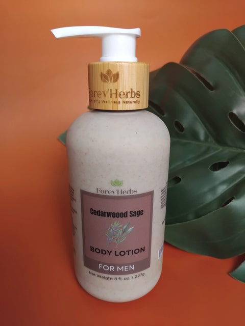 A bottle of Forev'Herbs Cedarwood Sage Lotion with a bamboo pump dispenser sits beside a large green leaf on an orange background, showcasing this natural men's lotion.